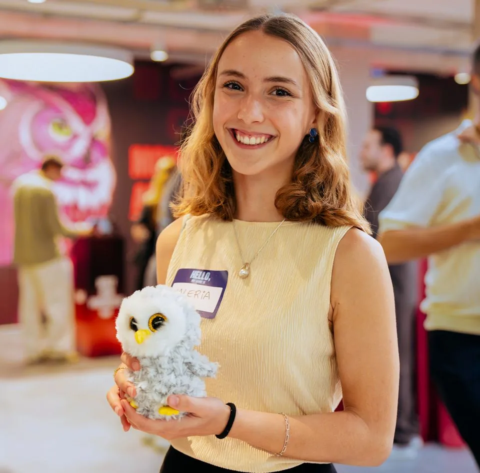 An attendee holding a small white toy owl.